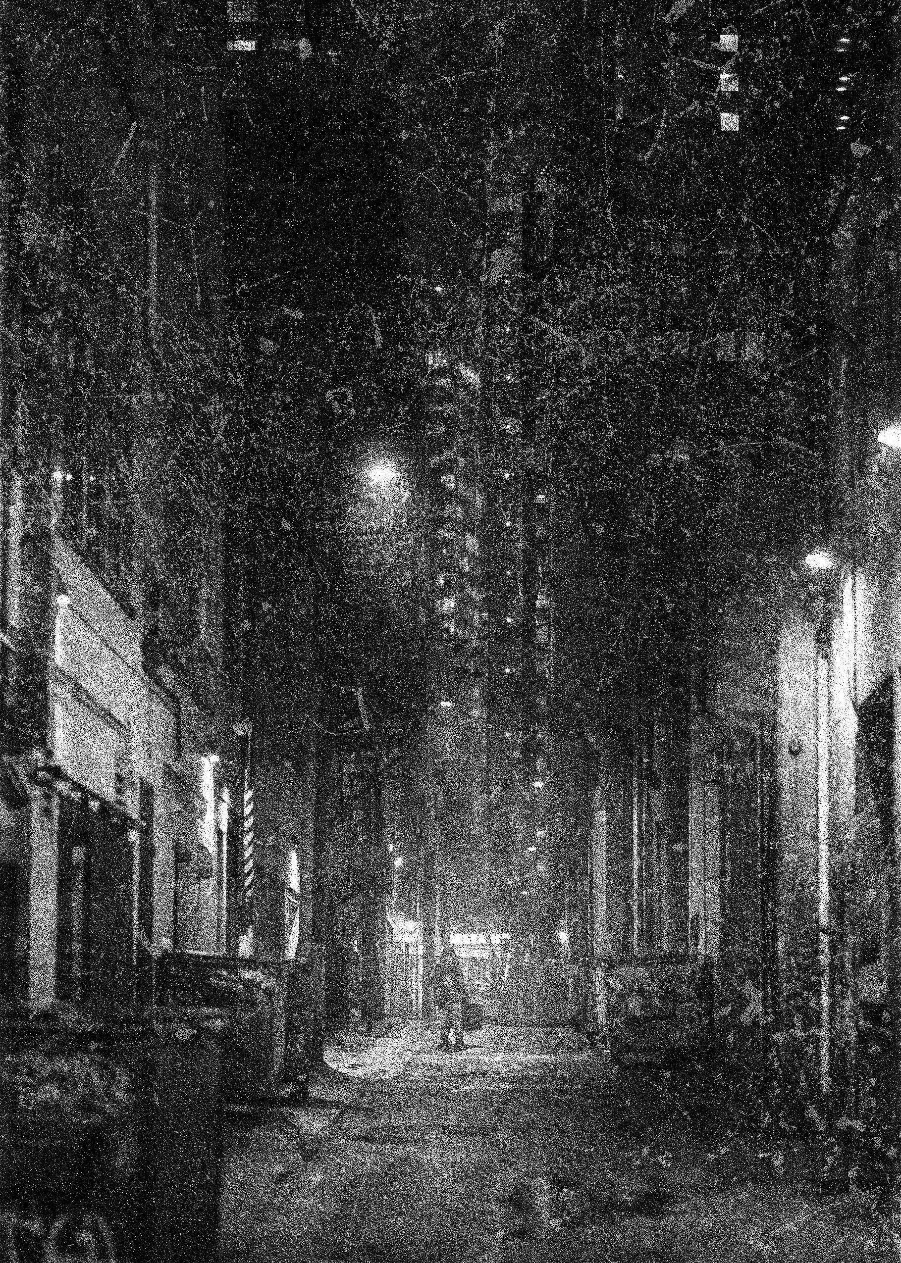 Black and white image depicting a rainy alleyway and lone figure holding a bulky bag.