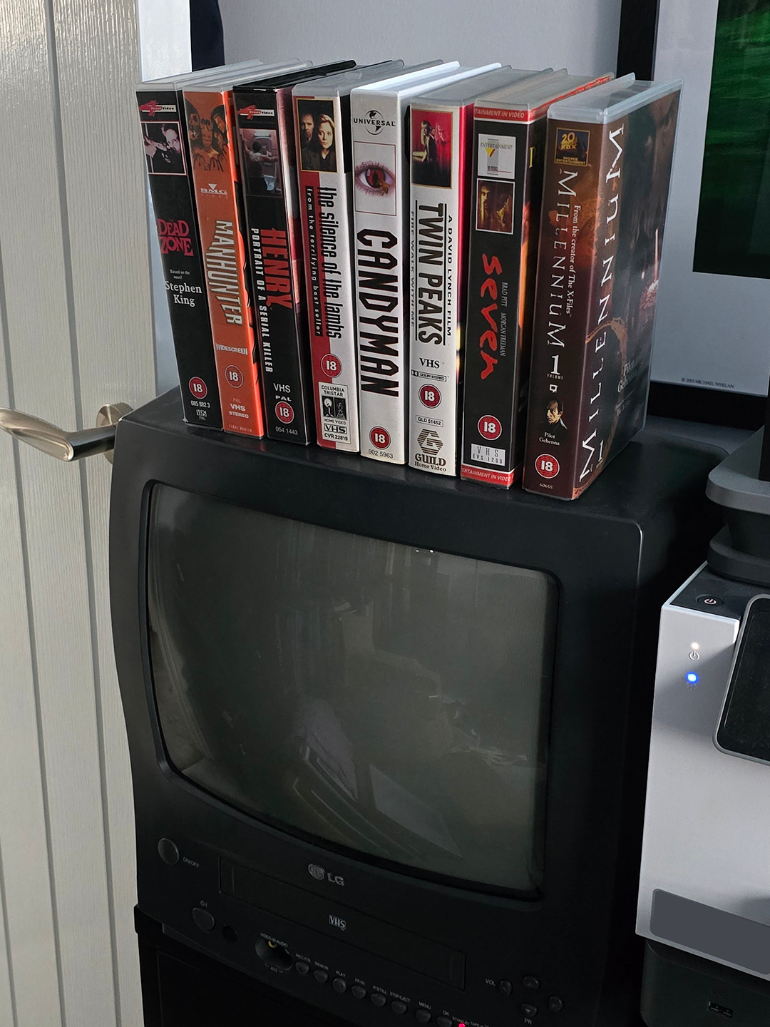 Stack of VHS tapes on top of a TV/VCR.